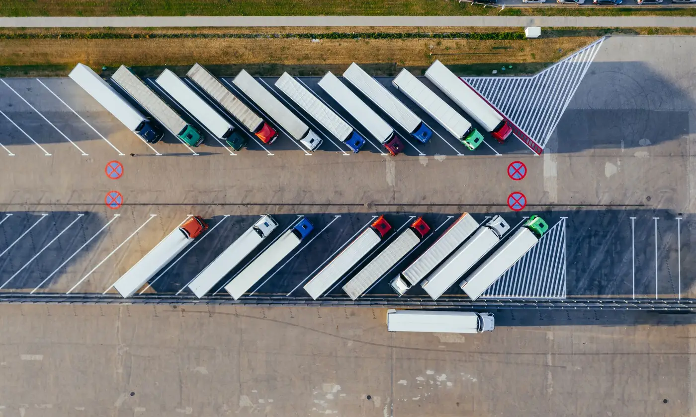 Overhead view of semi trucks parked at angles in a logistics lot
